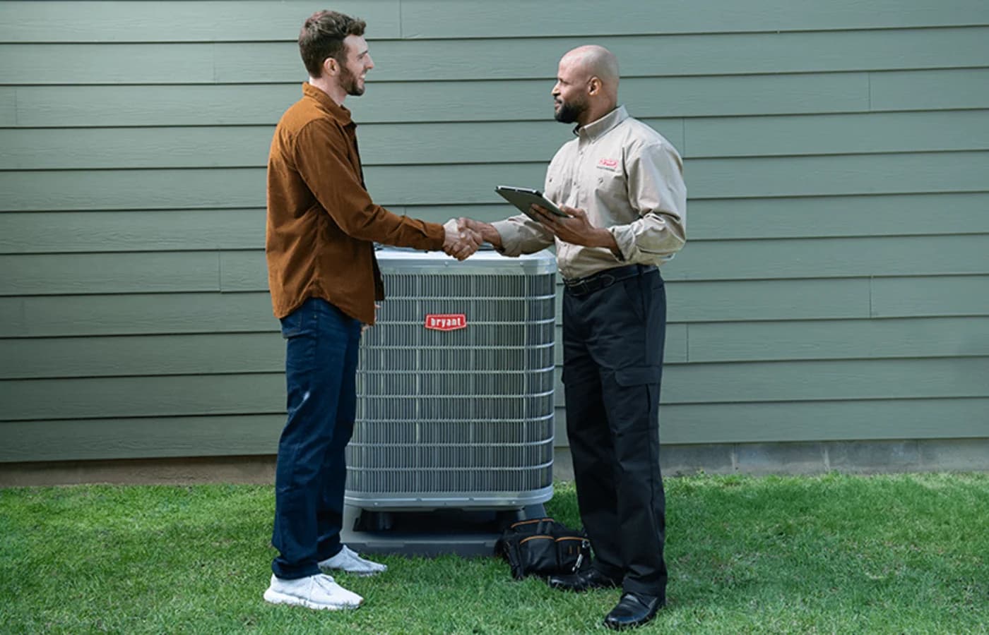 Bryant dealer discussing heat pump with a homeowner outside