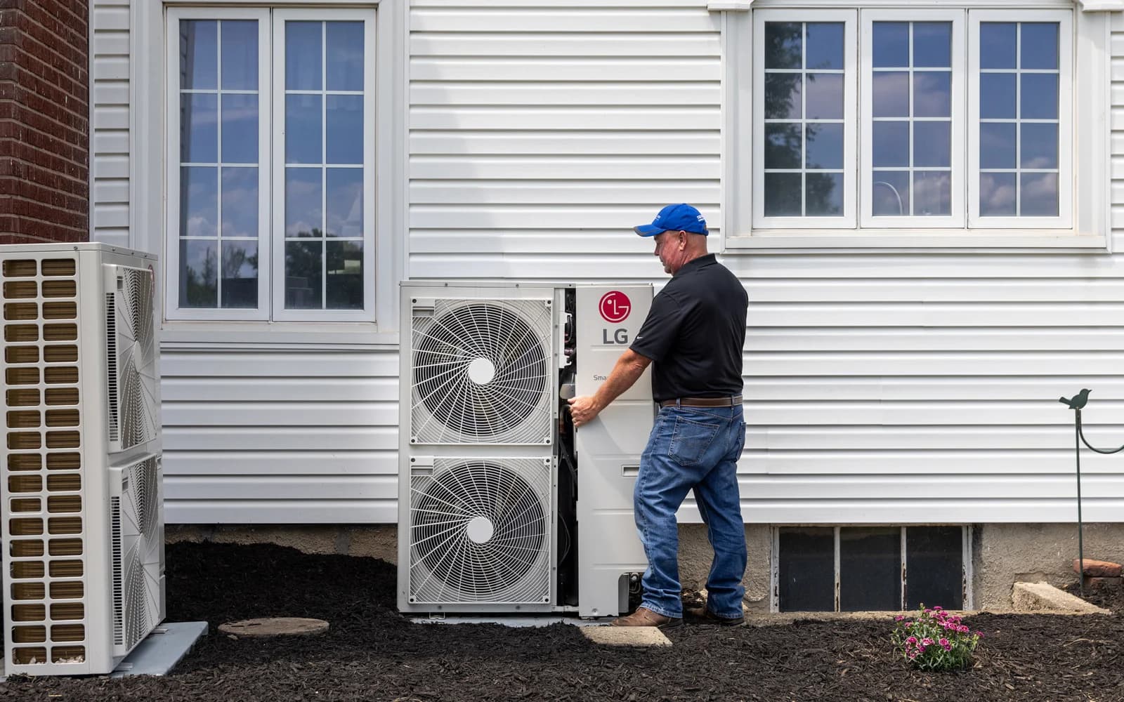 Installer working beside LG heat pump outdoor units