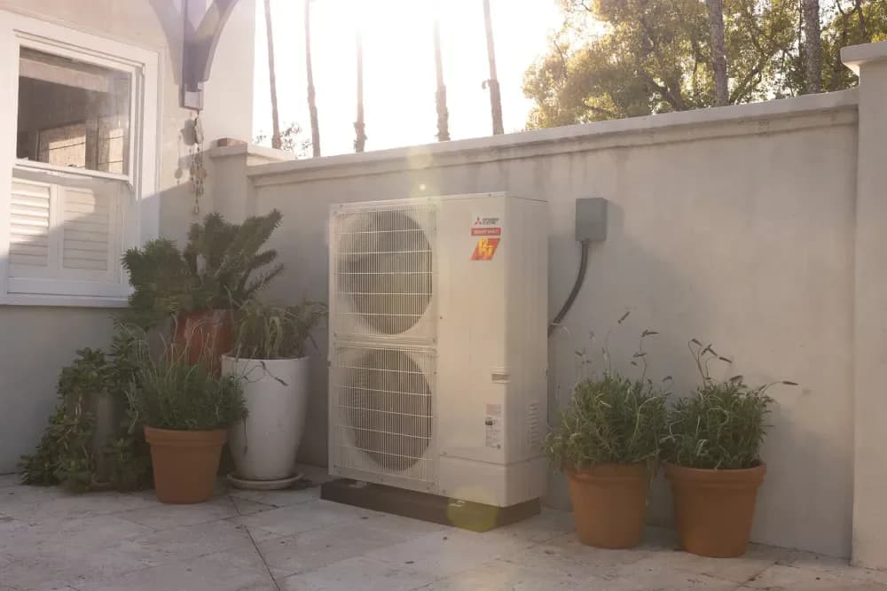 Mitsubishi Electric outdoor heat pump unit installed beside a patio