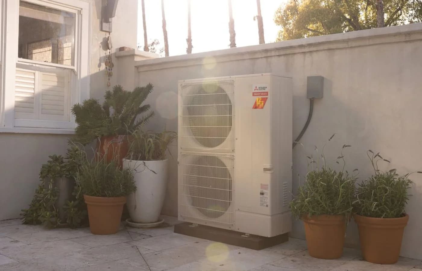 Mitsubishi Electric outdoor heat pump installed beside a home